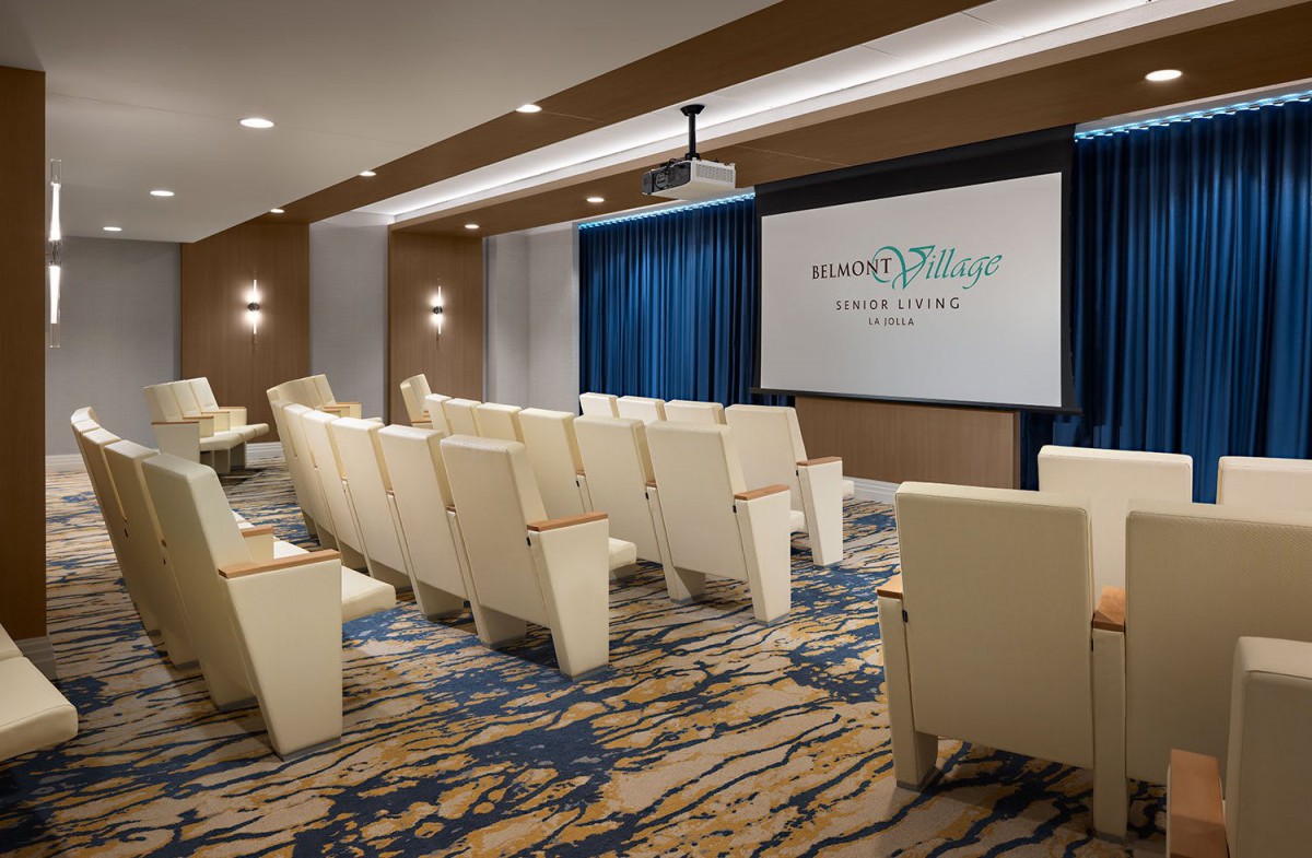 A modern indoor theater setup with comfortable seating and a projector screen.