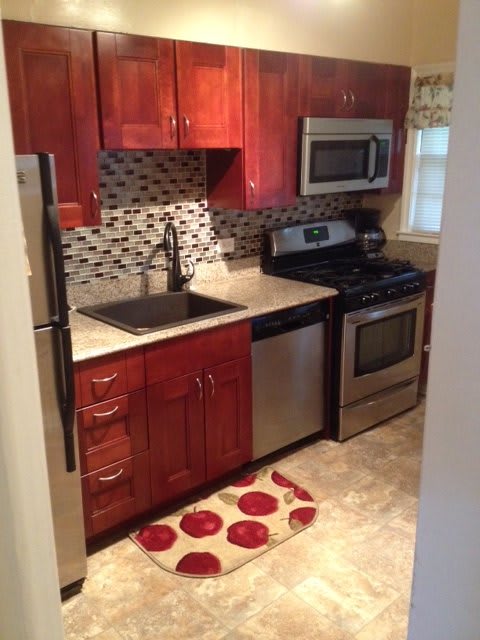 A modern kitchen with stainless steel appliances and wooden cabinetry.