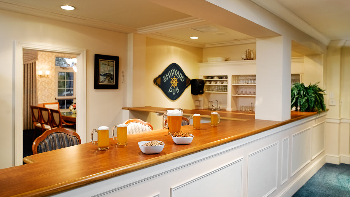 A cozy home bar setup featuring a wooden counter with glasses of drinks and decorative elements.