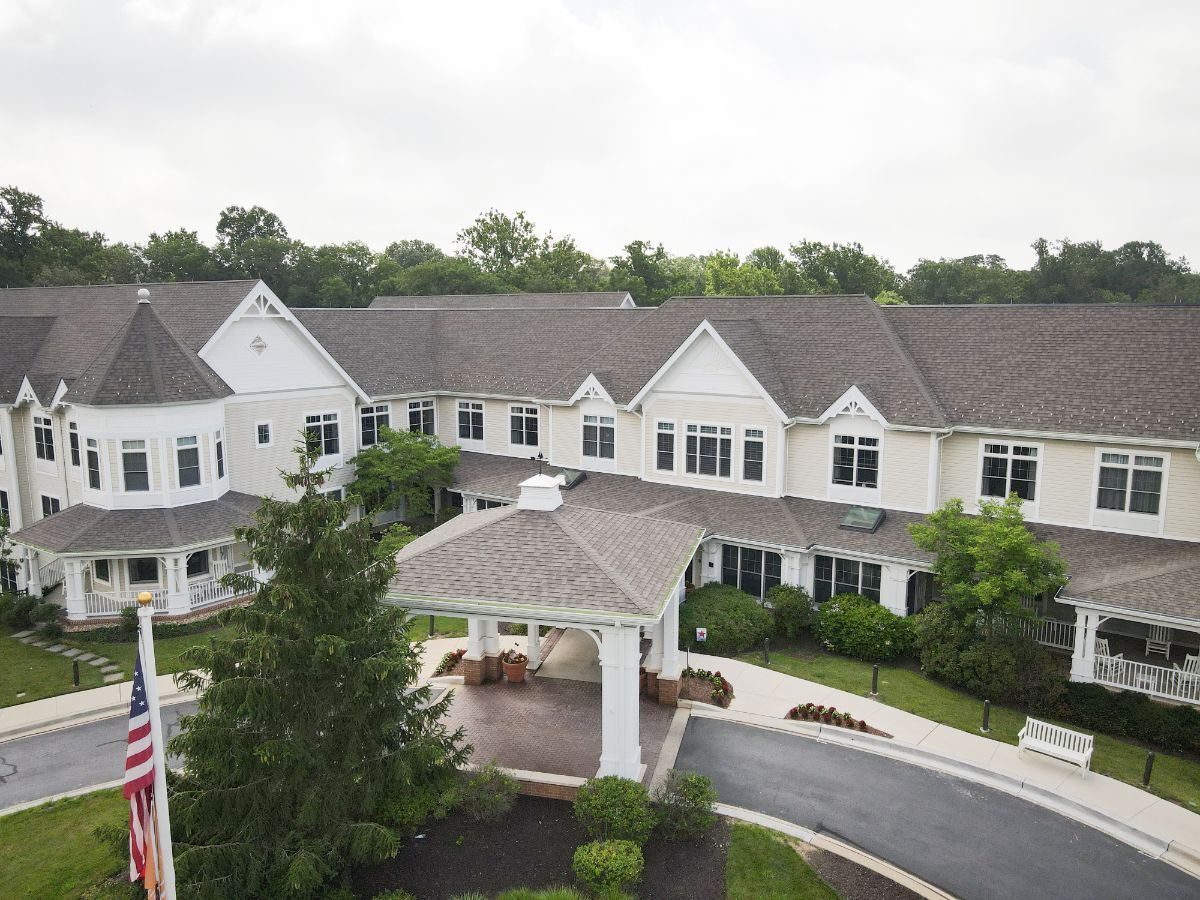 A large residential building with an entrance and landscaped surroundings.
