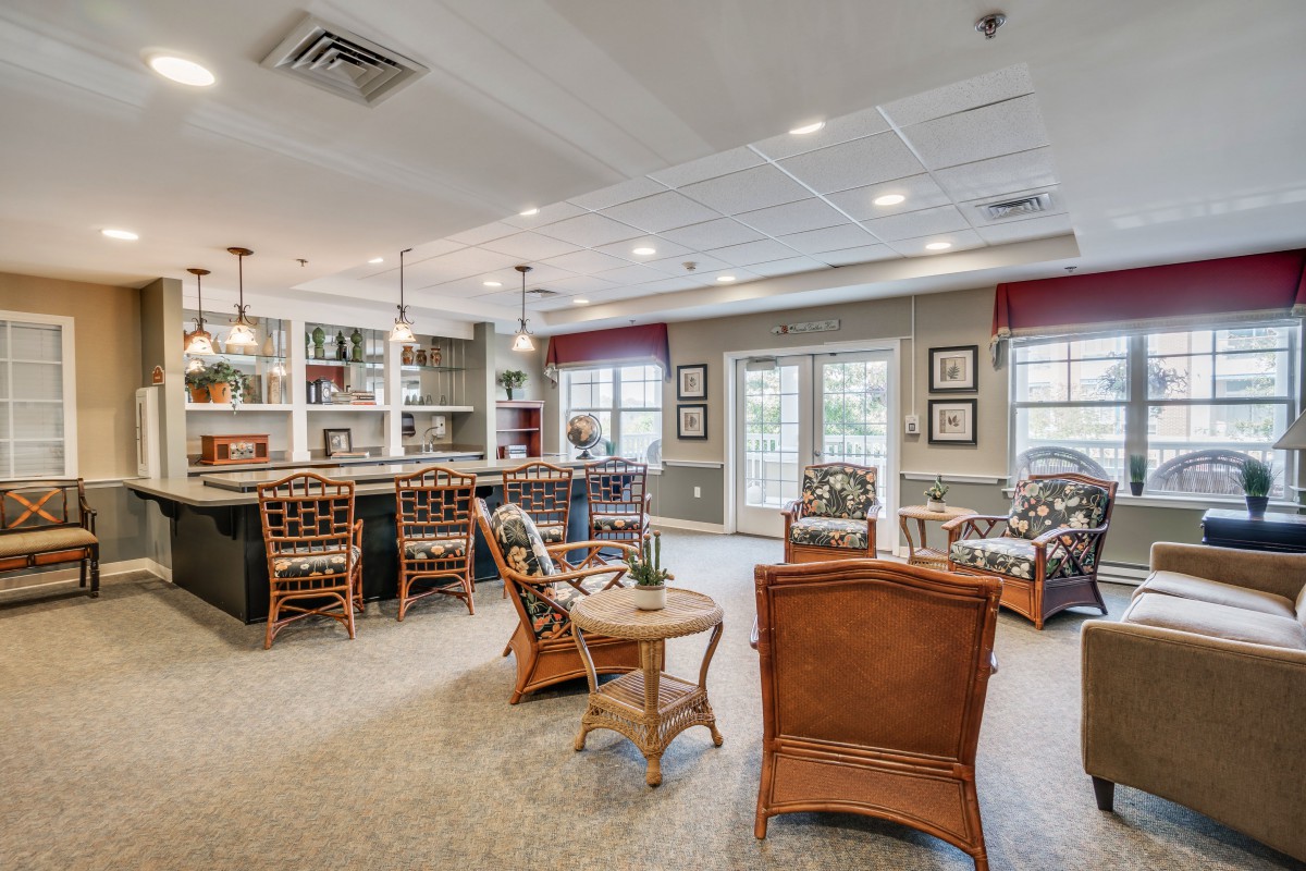 A spacious living area with a bar, comfortable seating, and large windows letting in natural light.