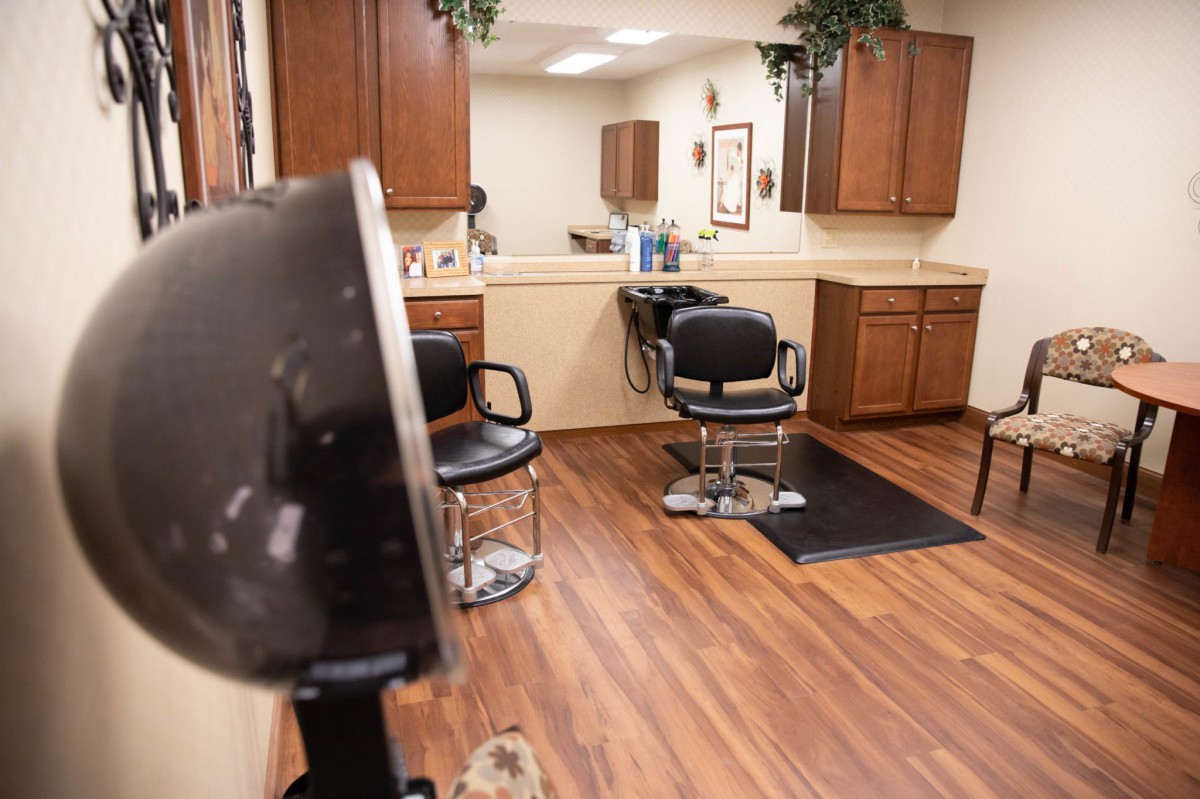 A cozy hair salon with barber chairs and wooden flooring.