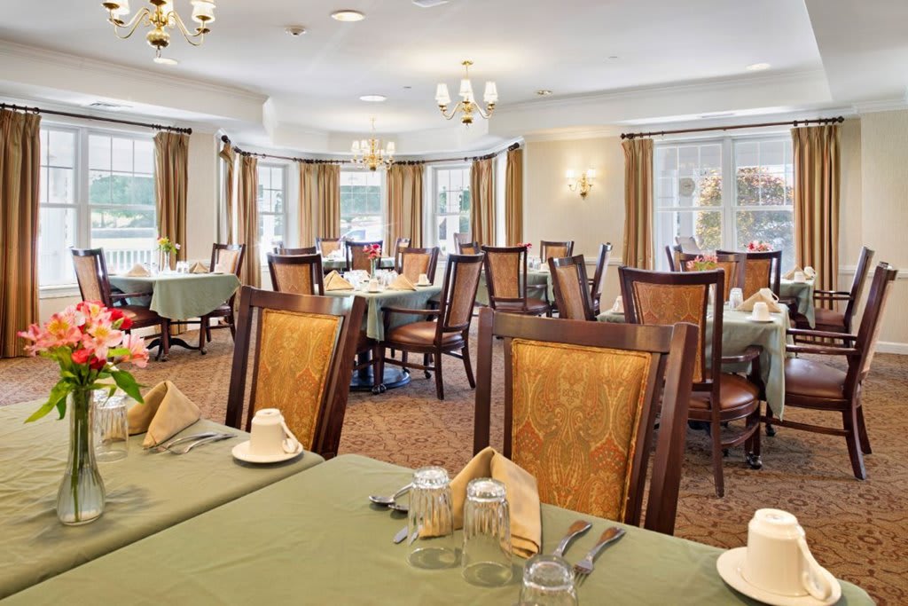 An elegant dining room setup with neatly arranged tables and chairs.