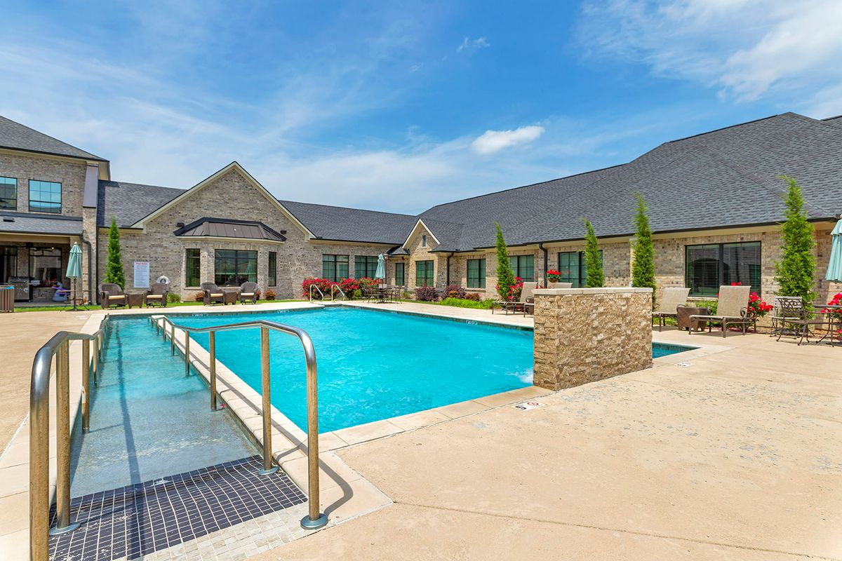 A modern residential building with a large outdoor swimming pool.