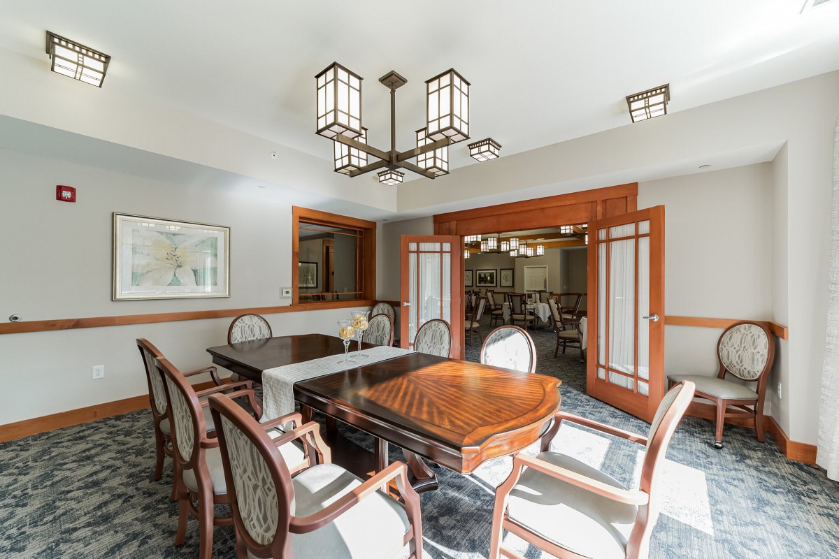 A well-appointed dining room with elegant wooden furniture and a modern chandelier.