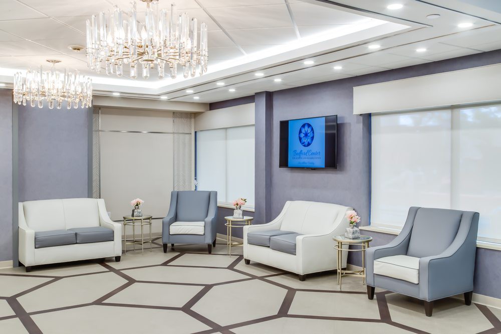 A luxurious and elegantly designed lounge area with modern furniture and a chandelier.