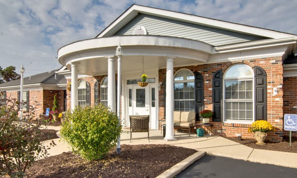 The front entrance of a building features classic columns and a covered porch.