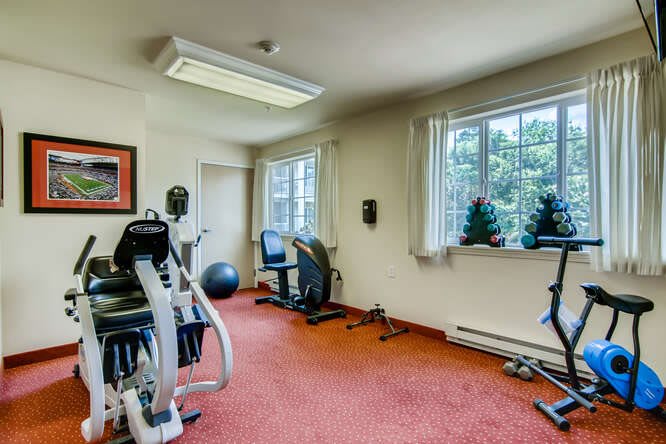 A compact indoor gym with various fitness equipment including an exercise bike and treadmill.