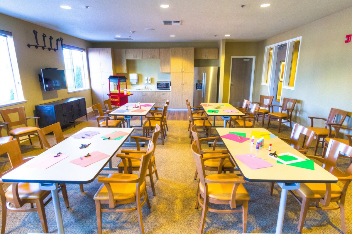 A brightly lit classroom with tables set up for arts and crafts activities.