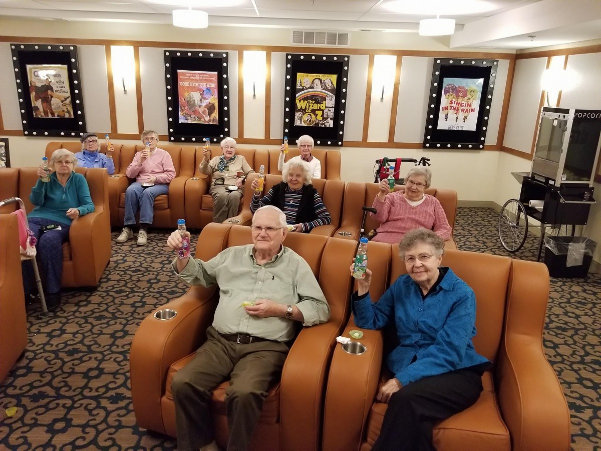 A group of seniors enjoying a movie screening in a cozy theater setting.