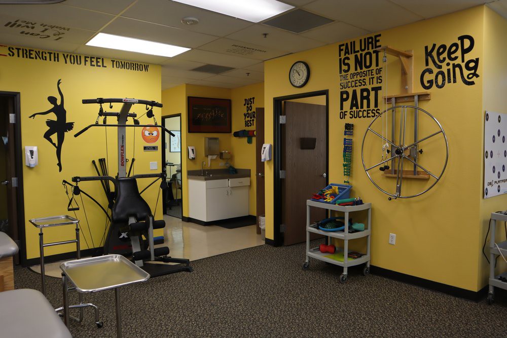 A fitness room with exercise equipment and motivational decor.