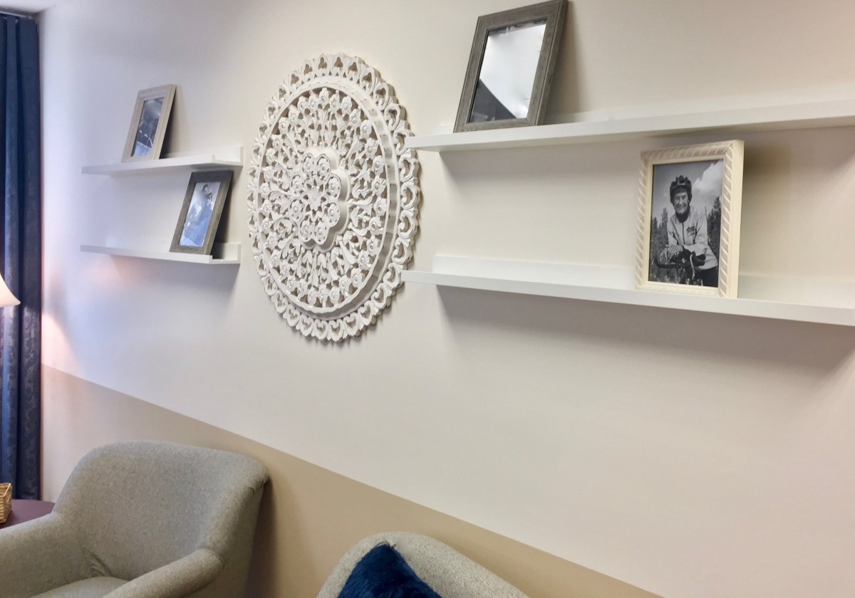 A cozy seating area with decorative shelves and a circular wall design.