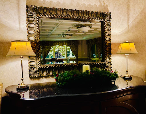 An elegant interior scene featuring a beautifully framed mirror, soft lighting from lamps, and tasteful decor.