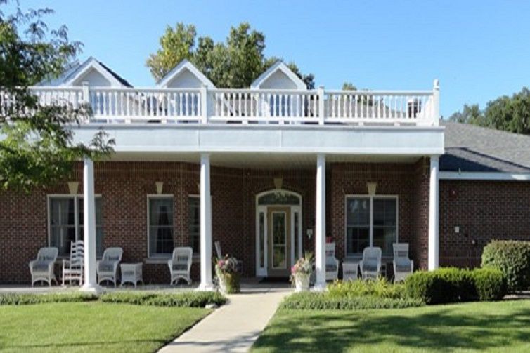 A traditional house with a spacious porch and outdoor seating.