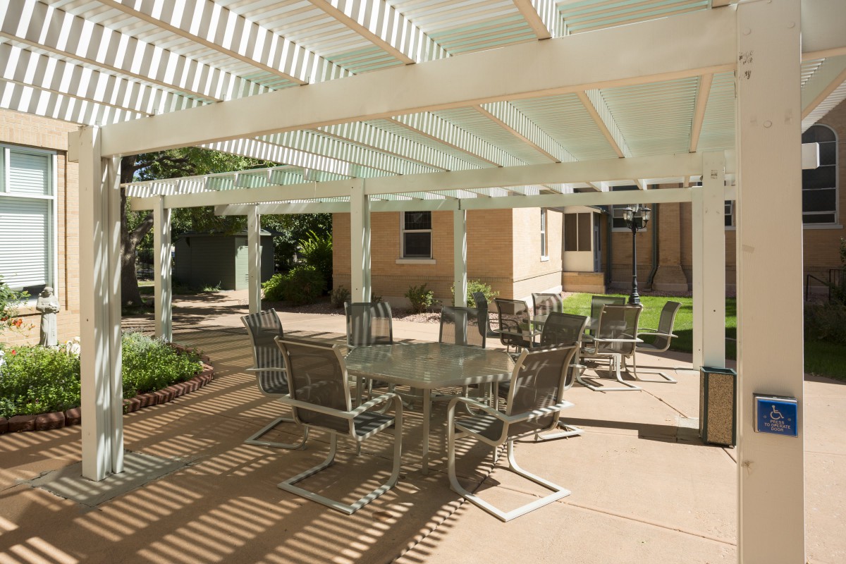 Outdoor patio area with a pergola and seating arrangements.