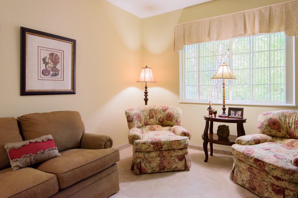 Cozy living room with armchairs, a sofa, and soft lighting.