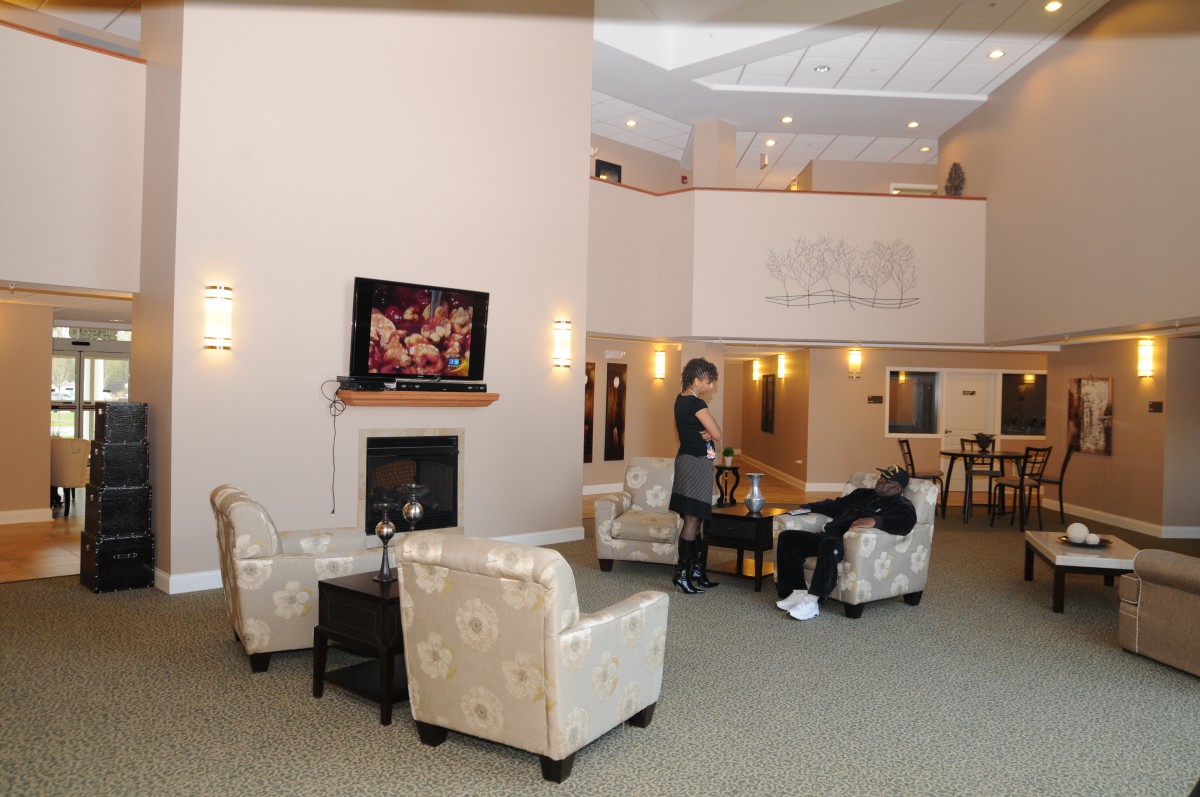 A spacious lobby with comfortable seating, a fireplace, and a television.