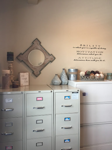 A cozy office space featuring stylish filing cabinets, a decorative mirror, and thoughtful wall art.