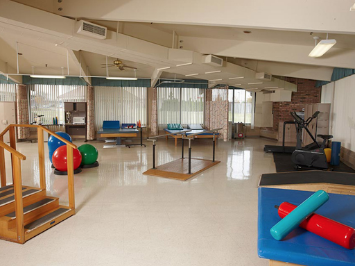 A spacious and well-equipped therapy room designed for rehabilitation exercises.