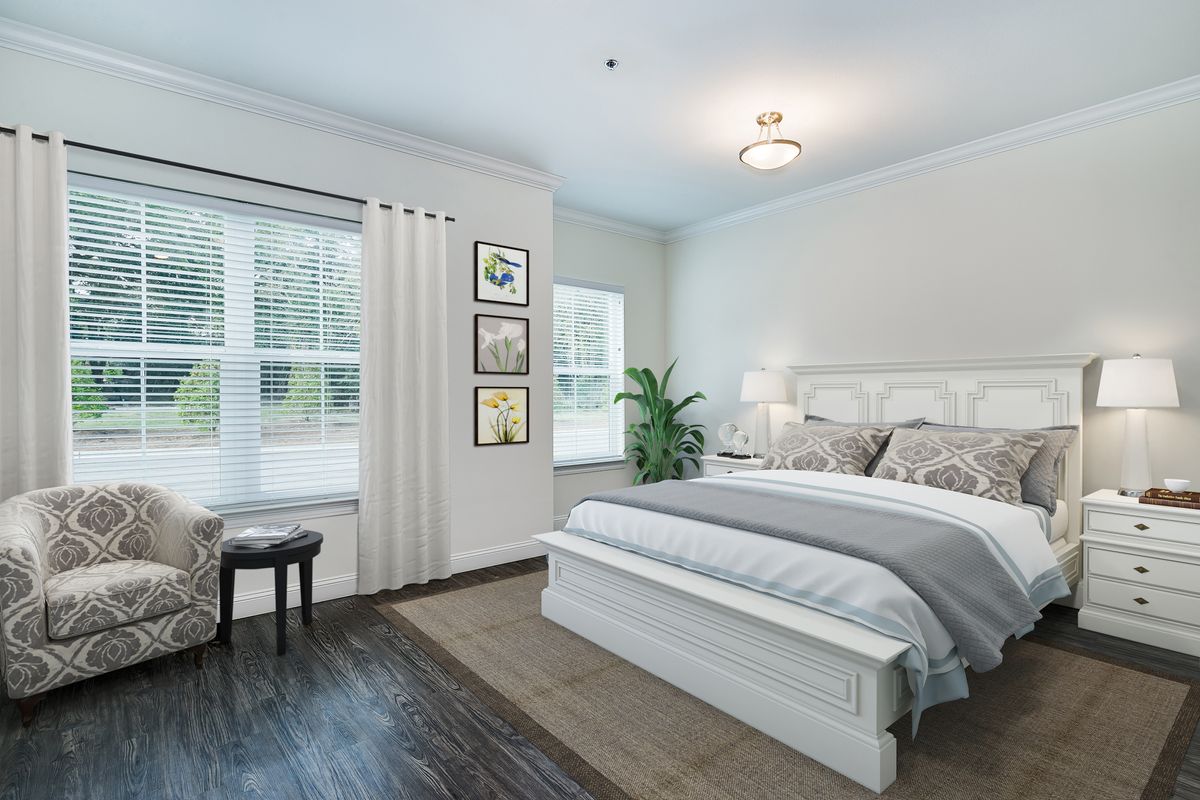 A modern bedroom with a comfortable bed, large windows, and stylish decor.