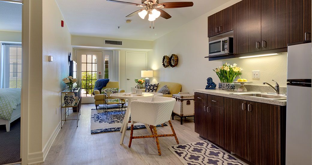 A cozy open-plan living and kitchen area with modern furnishings and bright lighting.