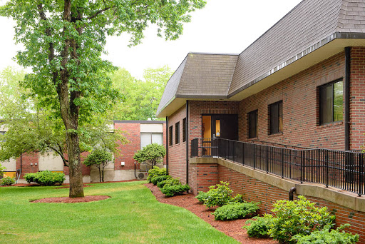 A tranquil scene featuring a brick building surrounded by lush greenery.