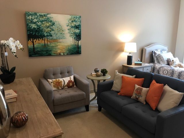 A cozy living room with a sofa, armchair, and decorative elements.