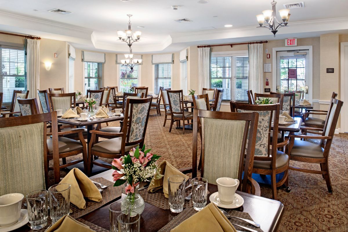 An elegant dining room with beautifully set tables and chandeliers.