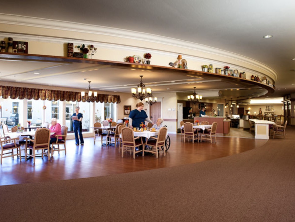 Spacious dining area with people gathered around tables.