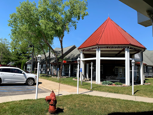 A view of a building with a striking red roof beside a fire hydrant in a landscaped area.