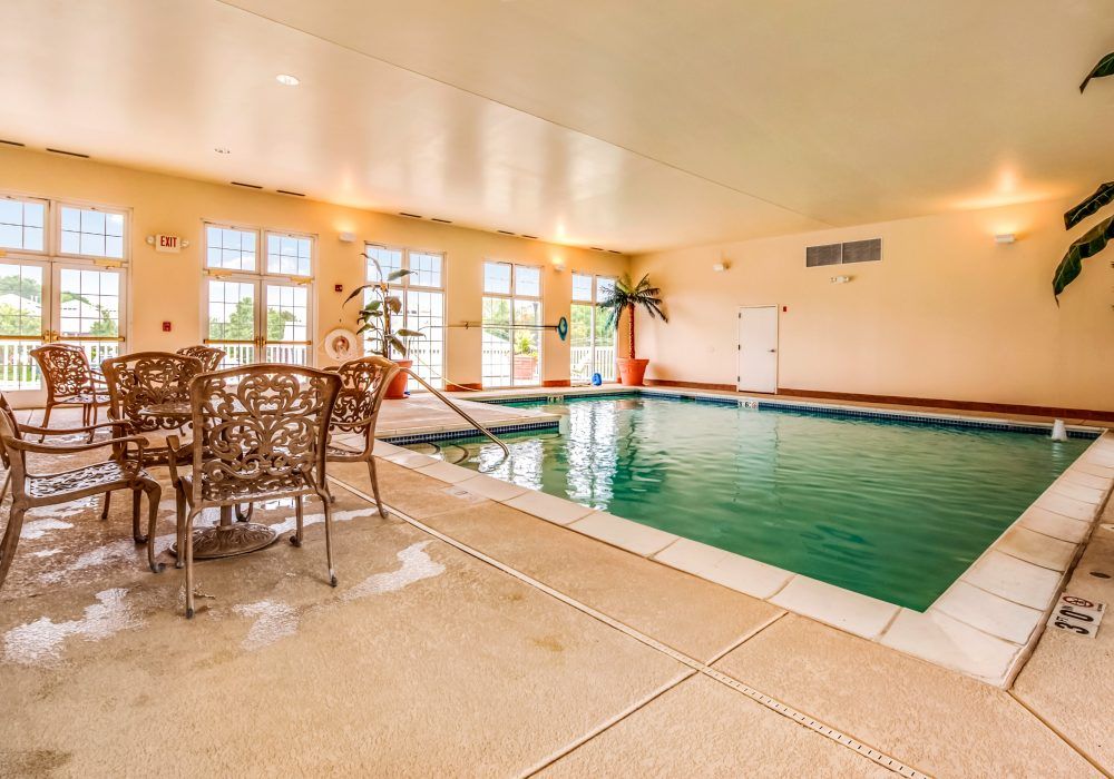 A cozy indoor pool area with seating and natural light filtering through large windows.