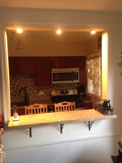 A cozy kitchen with a countertop seating area and warm lighting.