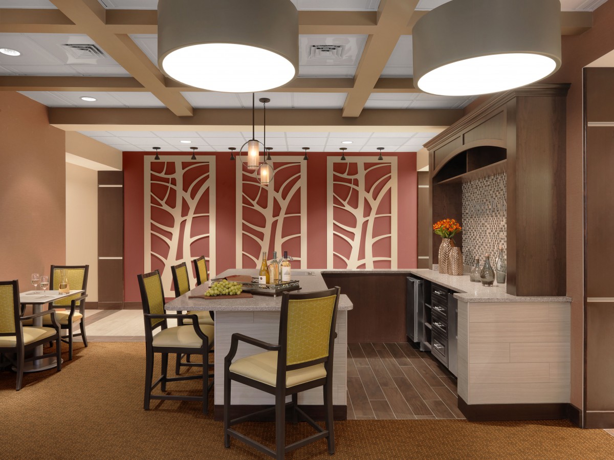 A modern kitchen with contemporary design elements, featuring a central island, stylish chairs, and decorative lighting.