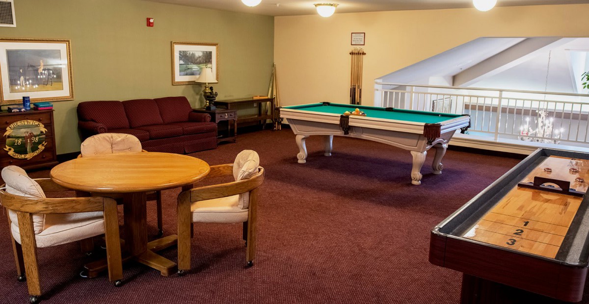A cozy game room featuring a pool table and seating area.