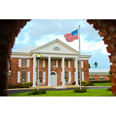 A classic building with columns and an American flag in the foreground.
