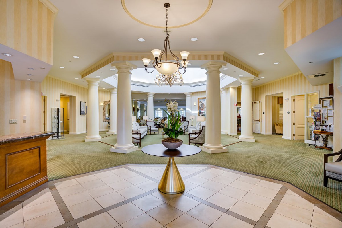 Luxurious lobby with chandelier, columns, and seating area.