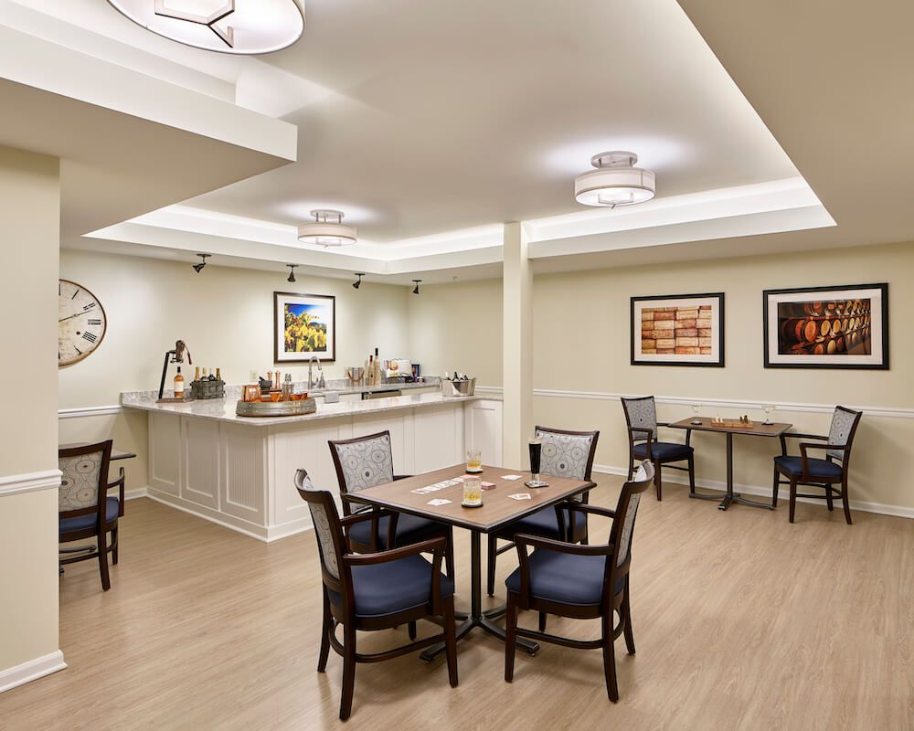 A modern dining area with tables and chairs, featuring minimalist decor and artwork on the walls.