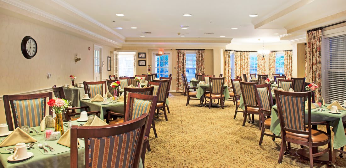 An elegant dining area with neatly arranged tables and chairs, featuring warm lighting and tasteful decor.