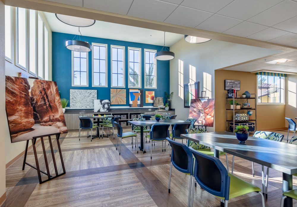 A modern classroom with large windows, bright lighting, and organized desks and chairs.