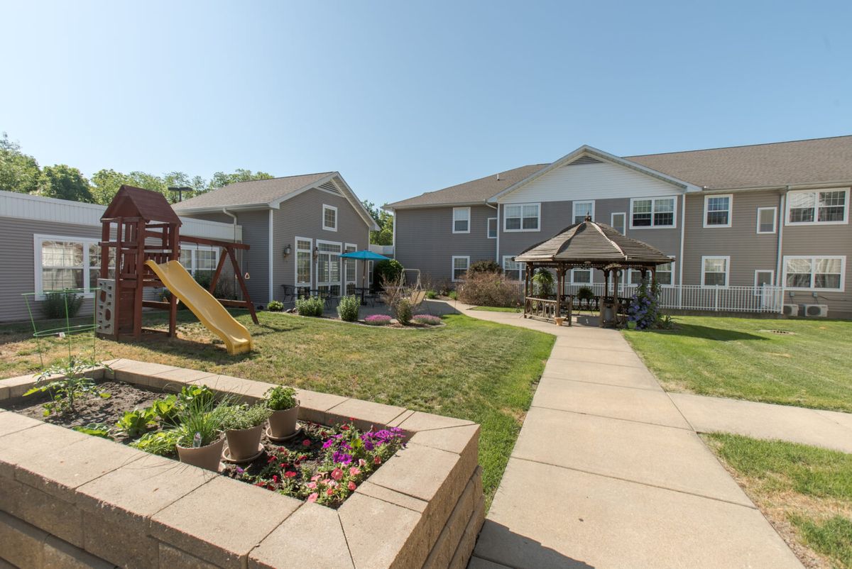 A residential courtyard featuring a playground, gazebo, and landscaped gardens.
