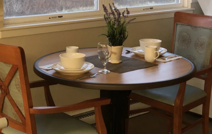A cozy table set for two with coffee cups and a decorative plant.