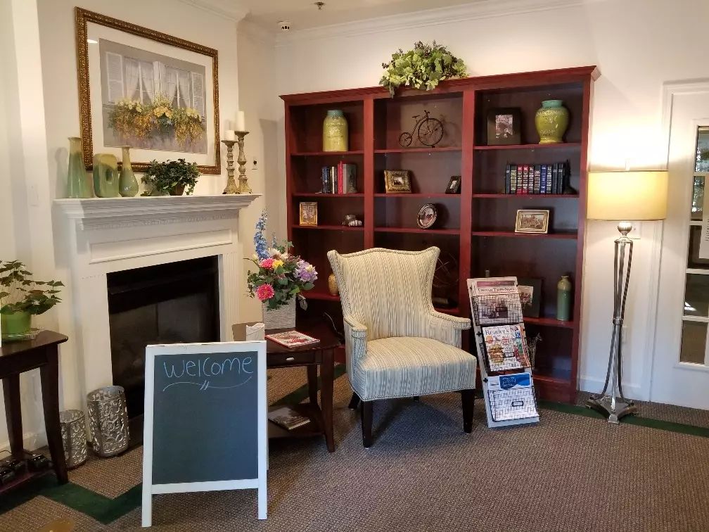 A cozy living room with a fireplace, bookshelves, and a comfortable chair.