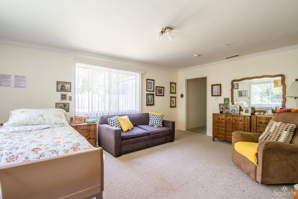 A cozy living space with a bed, couch, and various decorations.