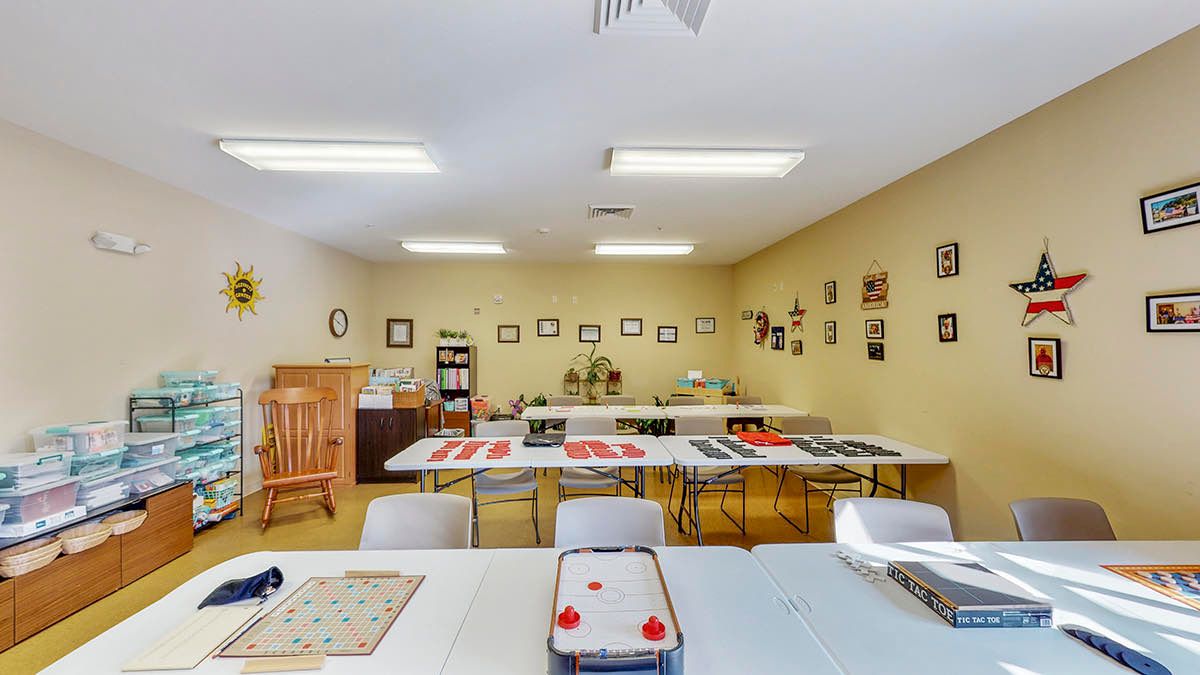 A classroom with tables and chairs arranged for activities, adorned with wall decorations and games.