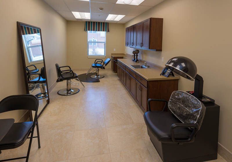 A hair salon interior featuring modern chairs, mirrors, and ample lighting.