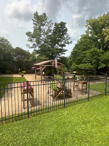 A serene outdoor space featuring fenced seating areas surrounded by lush greenery.