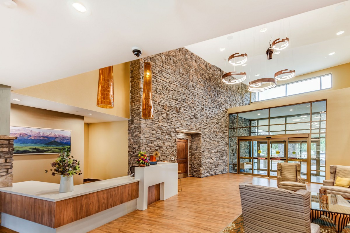 A modern lobby featuring a stone accent wall, stylish lighting fixtures, and comfortable seating.