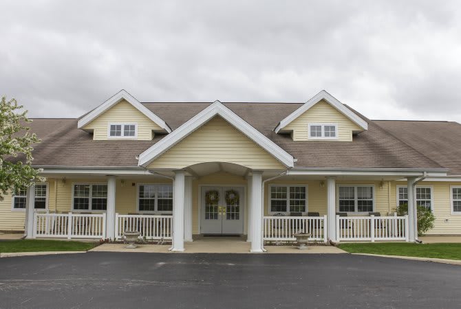 A front view of a residential house with a porch and gabled roof.