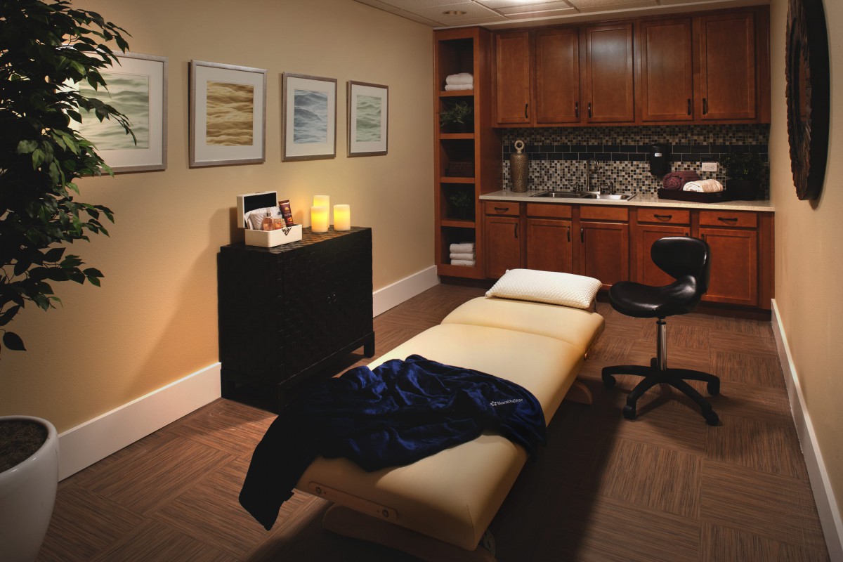 A cozy massage room designed for relaxation and therapy, featuring comfortable furnishings and a tranquil atmosphere.