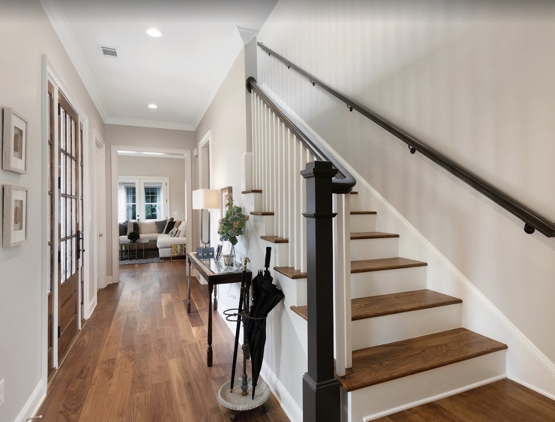A stylish hallway with a wooden staircase and elegant decor.